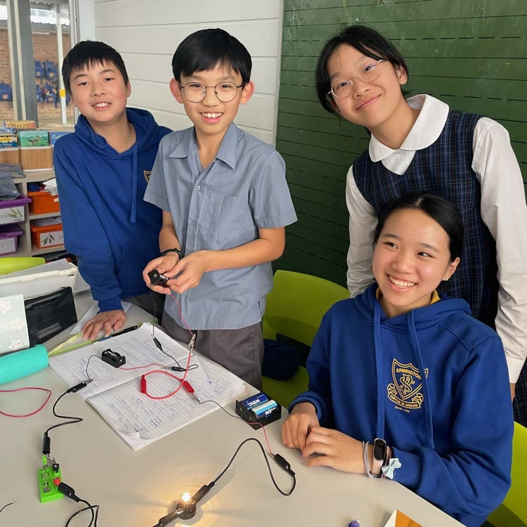 Four students working on electrical circuits