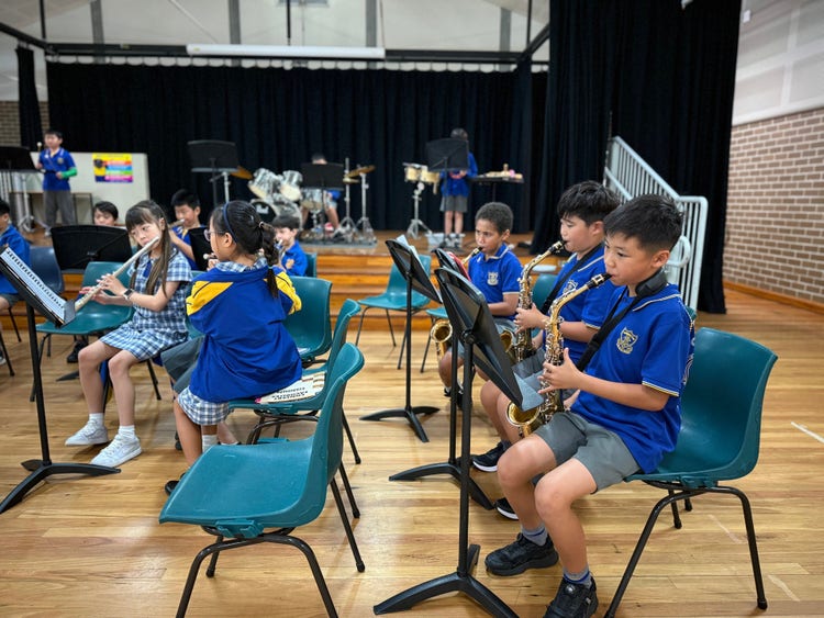 Band students playing their instruments in the school's hall