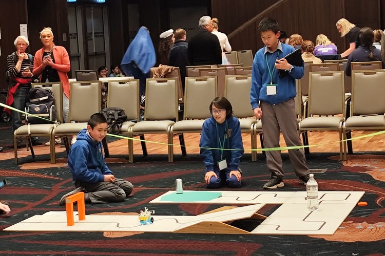 three students participating in the robocup