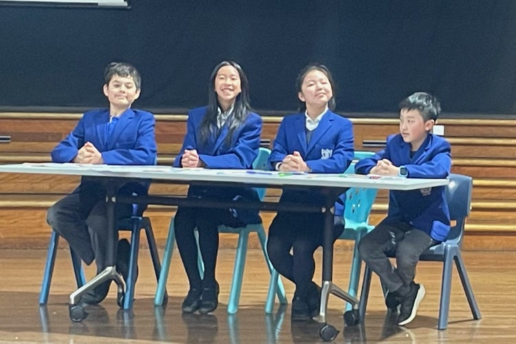 four debating students sitting at a table